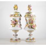 Pair of Carlsbad Victoria porcelain pedestal vases, urn form with domed covers, printed panels,