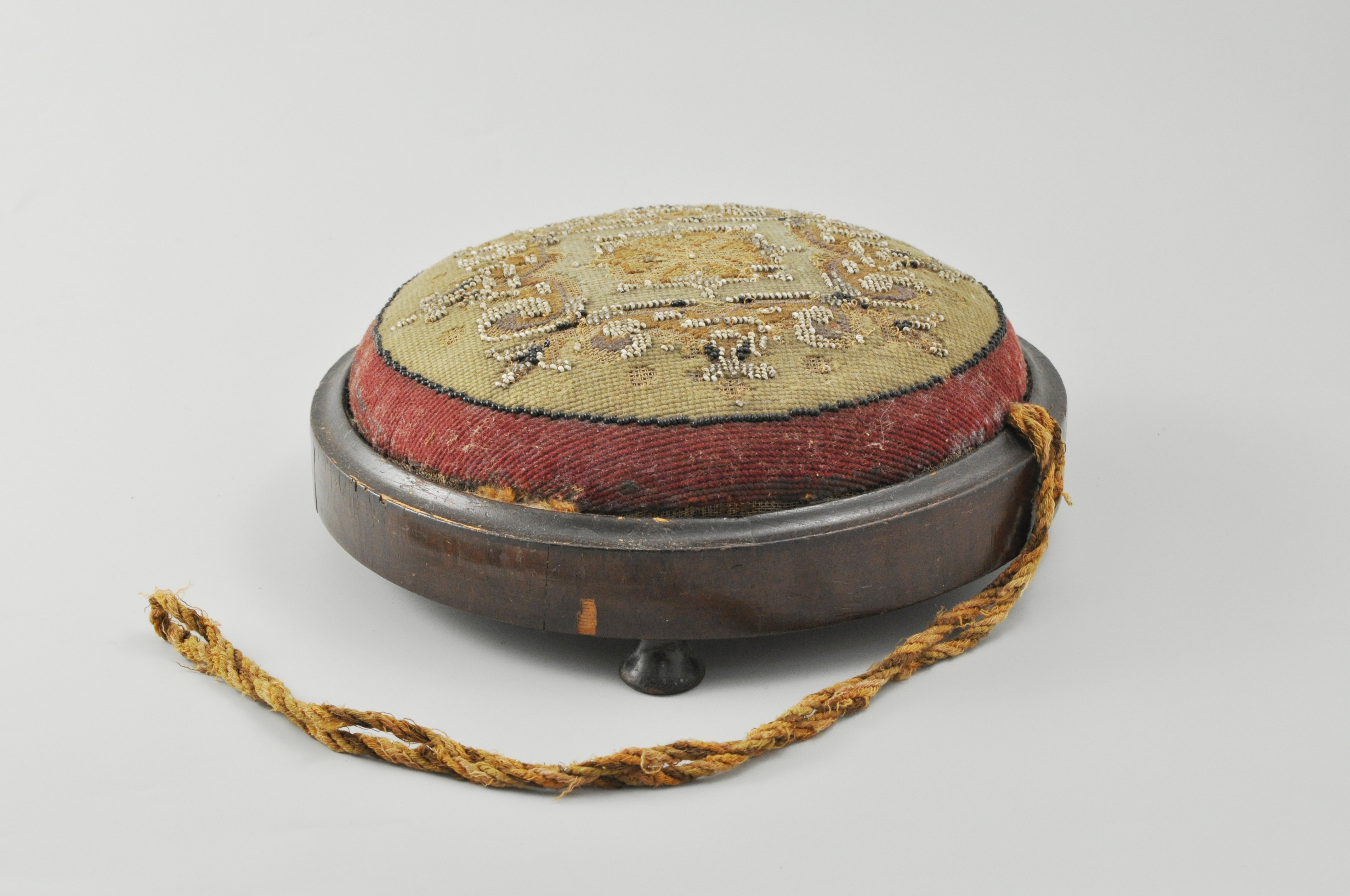 Victorian footstool, circular bead work top, bun feet, diameter 27cm, (a.f.).