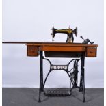 Singer treadle sewing machine, oak and iron, folding lid enclosing the machine above drawers,