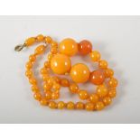 Amber bead necklace, butterscotch colour, approximately 20mm diameter and smaller, length 51cm.