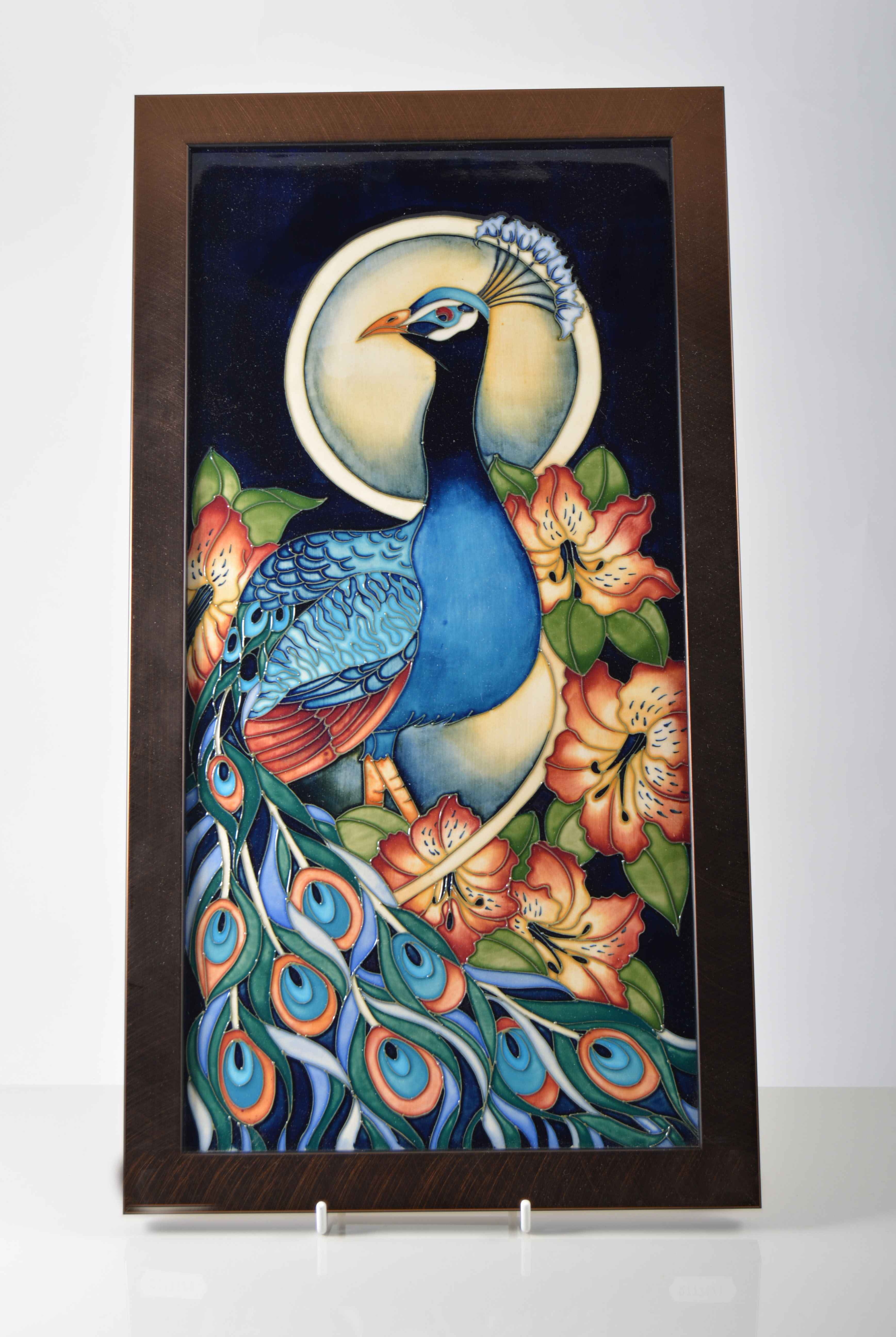 Moorcroft plaque in the Peacock design, 45cm x 24cm, by R J Bishop 2007, in bronzed metal frame.