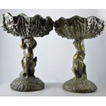 Pair of bronzed effect plaster comports, bowls upheld by cherubs, 37cm.