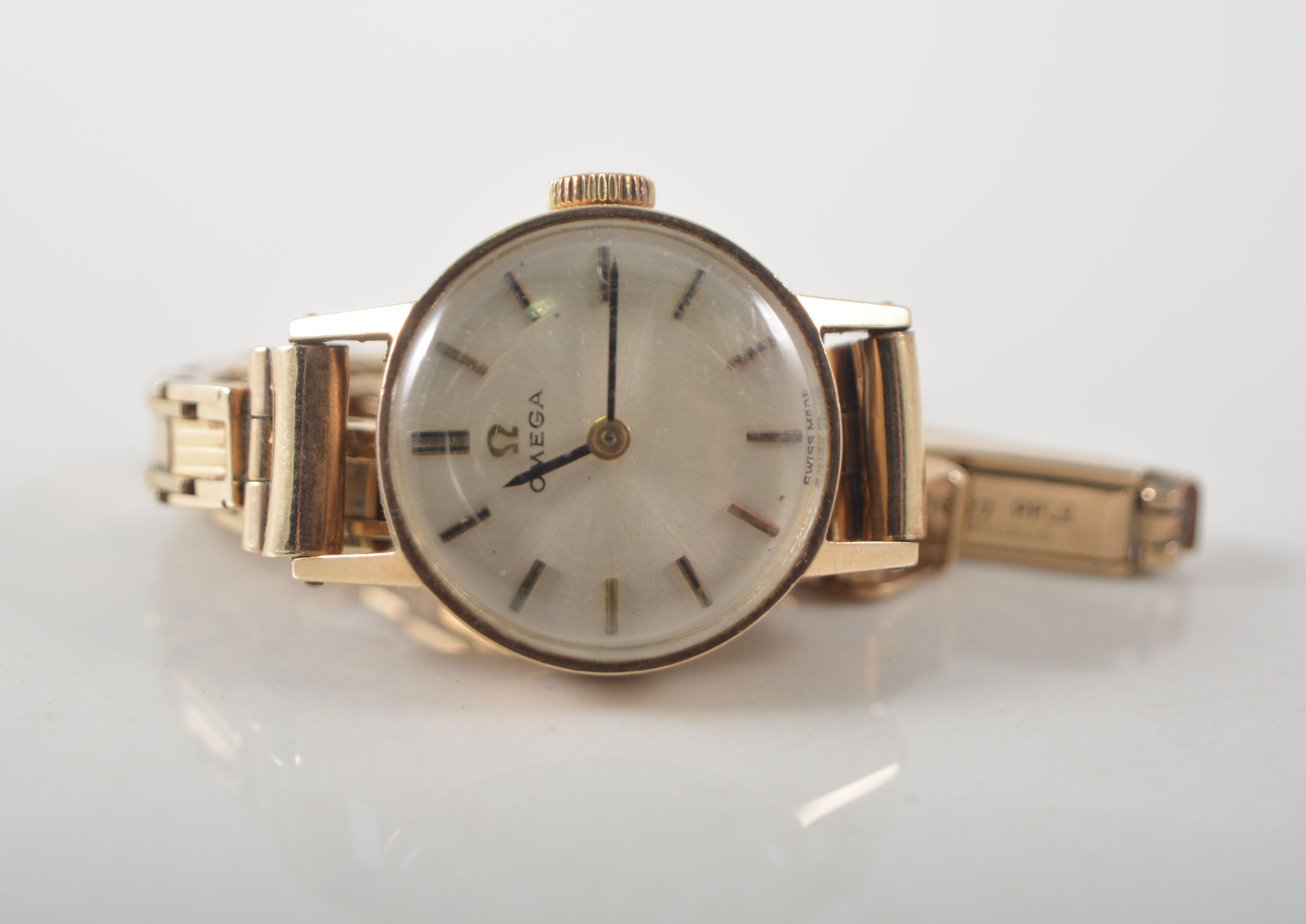 Ladies Omega wristwatch, circular dial with baton markers, 9ct gold case and bracelet strap.