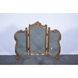 Moulded and gilt dressing table mirror, with three shaped panels, scrolled legs, height 54cm.