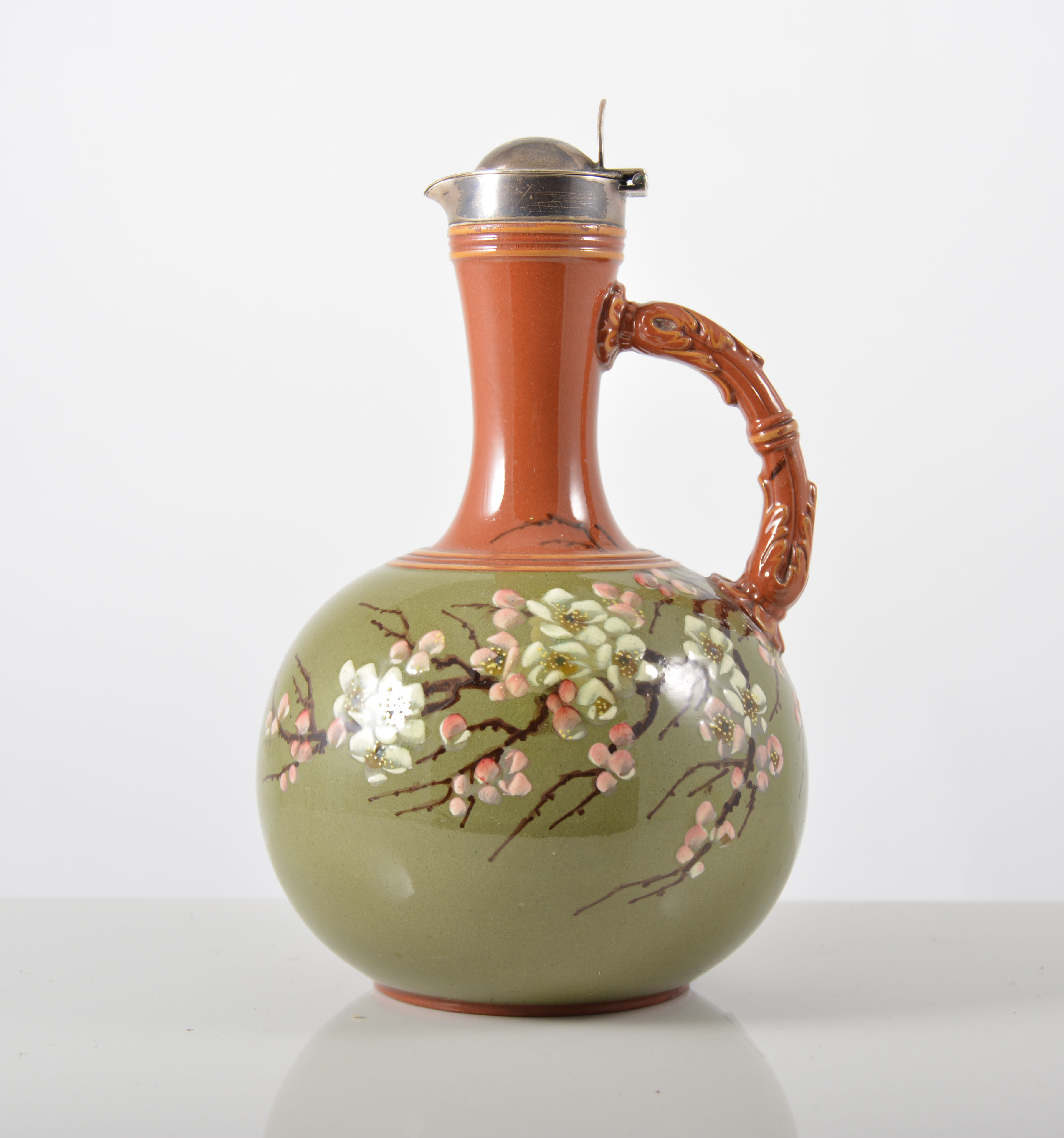 Torquay style pottery ewer, green glazed with blossom spray, silver cover, Sheffield 1879, 18cm.