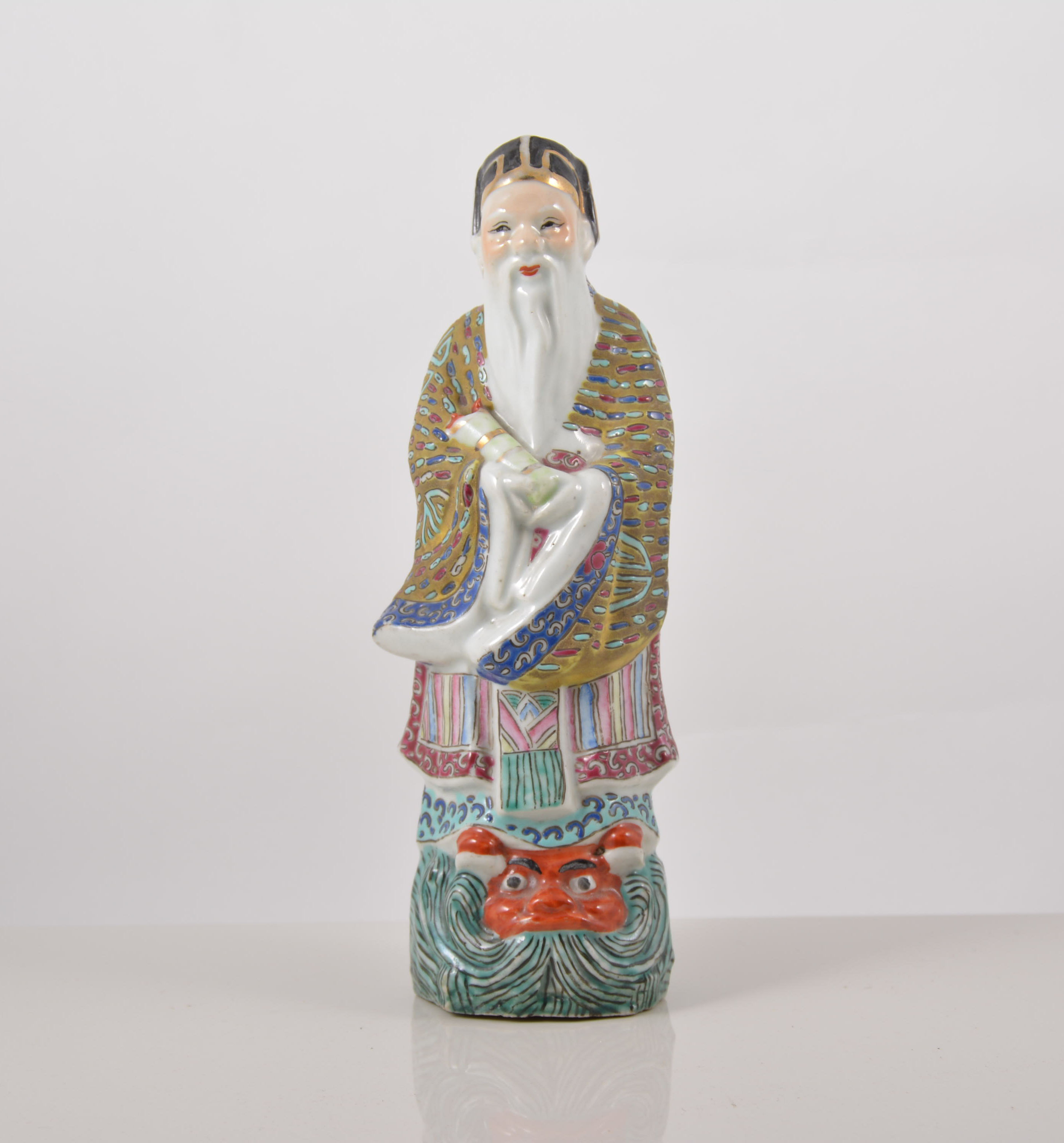 Chinese polychrome figure, of an Immortal carrying a scroll, 23cms.