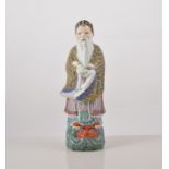 Chinese polychrome figure, of an Immortal carrying a scroll, 23cms.