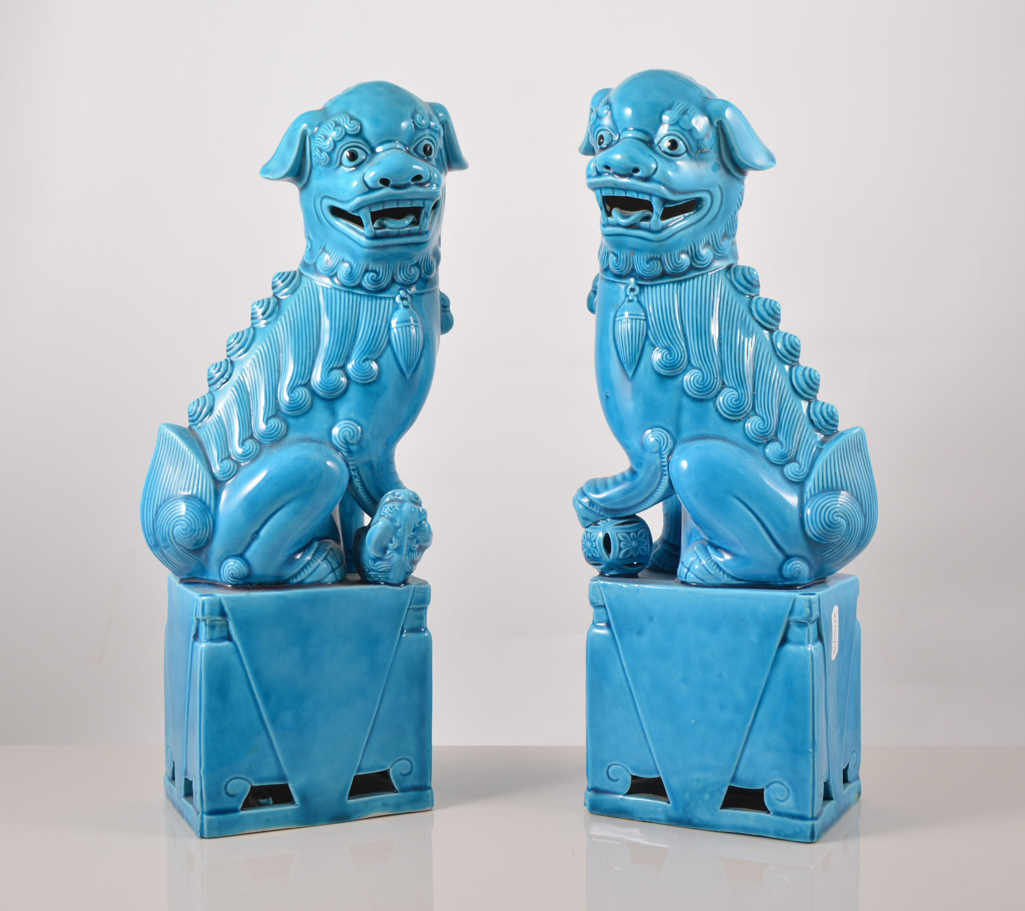 Pair of Chinese turquoise glazed models of Temple Lions, each set on a rectangular plinth, 35cms.