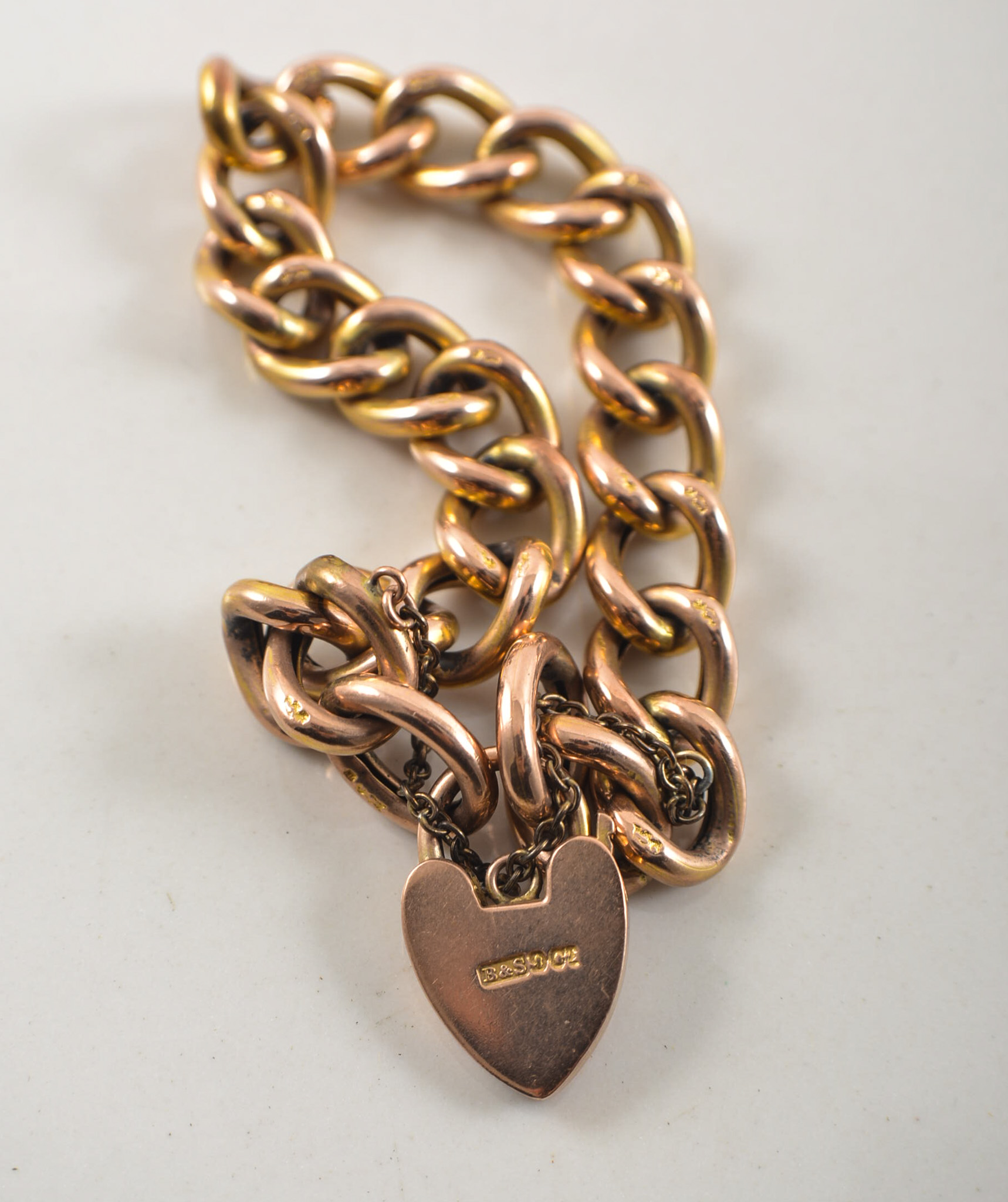 Rose metal hollow curb link bracelet, with a padlock fastener.