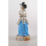 Continental porcelain figure of a young lady, in 18th Century dress holding a rose,