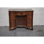George III style mahogany kneehole desk, serpentine top with tooled and gilt leather insert,