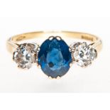 A sapphire and diamond three stone ring, sapphire (1), oval mixed cut stone, diamonds (2),