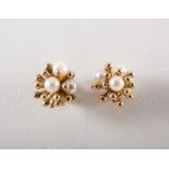A pair of 9 carat yellow gold pearl stud earrings, each earring is peg set with four 3.