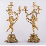 A pair of Louis Philippe style gilt metal three light candelabra, modelled with cherubs,