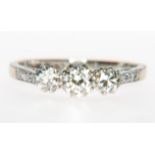 A traditional diamond three stone ring, the old brilliant cut stones, slightly graduating in size,