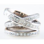 A diamond set dress ring, having three interlocking white metal bands,