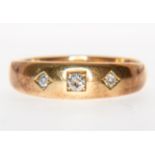An 18 carat yellow gold three stone diamond gypsy ring, star set with three old cut diamonds,