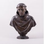 A bronze portrait bust, probably St Francis of Assisi, circular socle, 24cm.