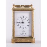 A French gilt brass carriage clock, with engraved foliate and scrolled decoration,