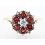 A garnet and diamond circular cluster ring,