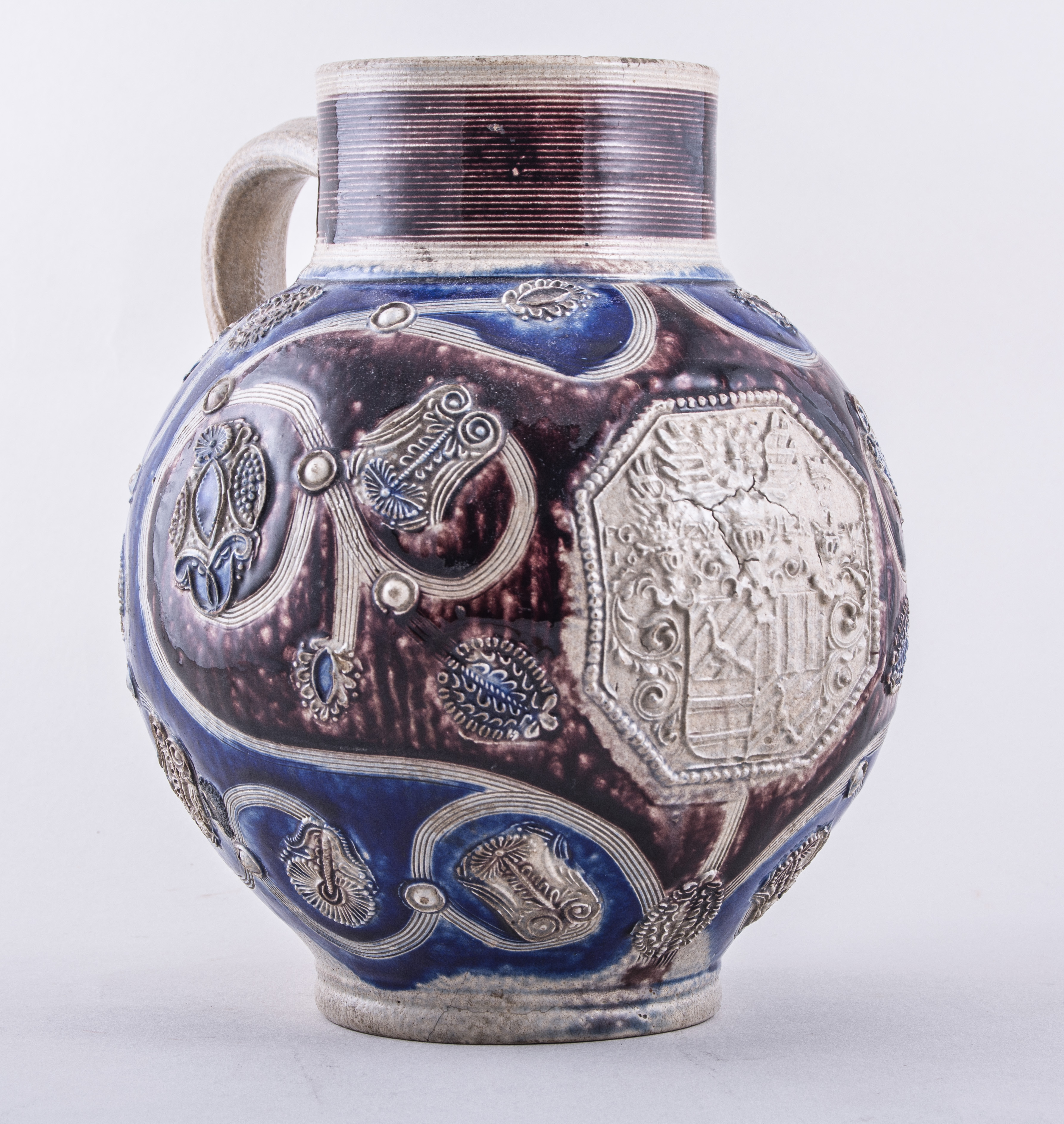 A Westerwald grey salt glazed stoneware armorial jug, initialled and dated 1687,