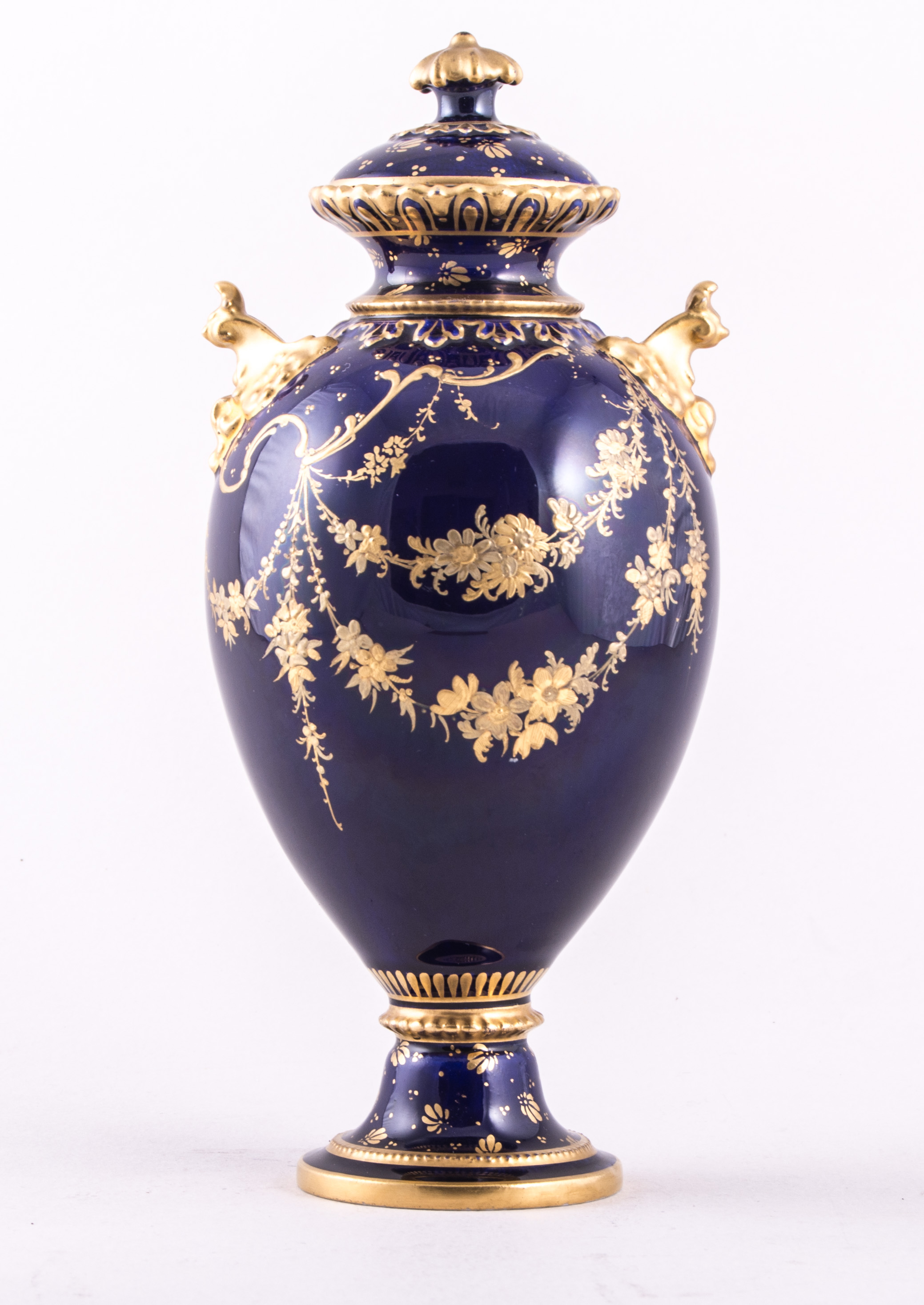 A Royal Crown Derby bone china royal blue ground urn shape covered vase, 1895, with scroll handles,