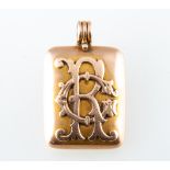 A yellow metal locket, rectangular with a plain polished finished and applied monogram CR,