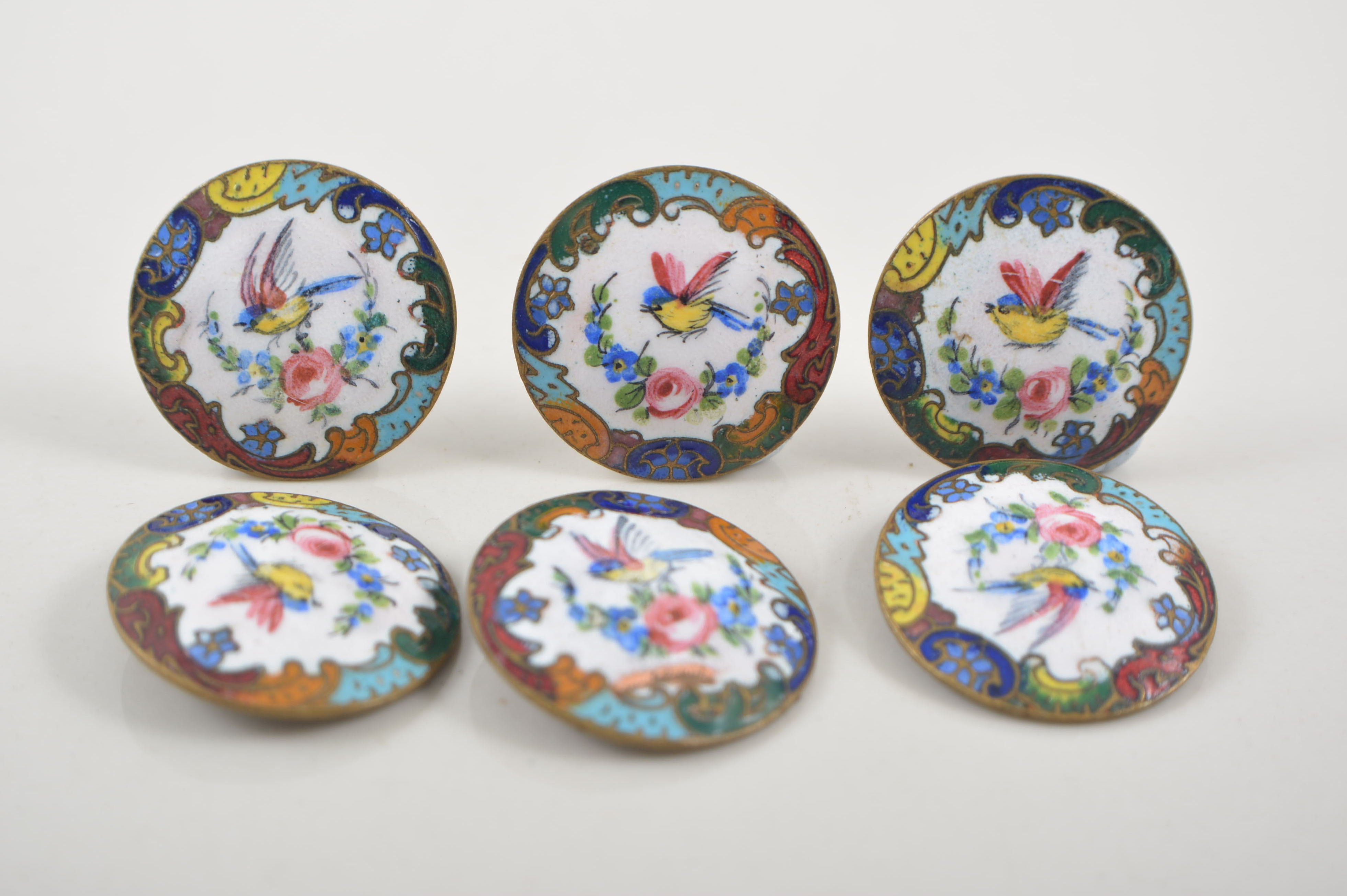 Set of six enamelled buttons.