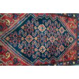 Small Persian pattern rug, blue ground, lozenge medallion with stylised flowers, red spandrels,