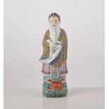 Chinese polychrome figure, of an Immortal carrying a scroll, 23cm.