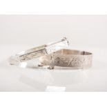 Solid silver half hinged bangle with bright cut engraving on a textured background,