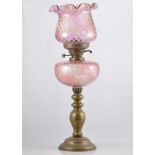 Brass oil lamp, pink tinted moulded reservoir, shade, height overall 59cm.