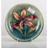 Walter Moorcroft, 'Freesia', a shallow dish/ plate, designed with a single flower, on shaded green,