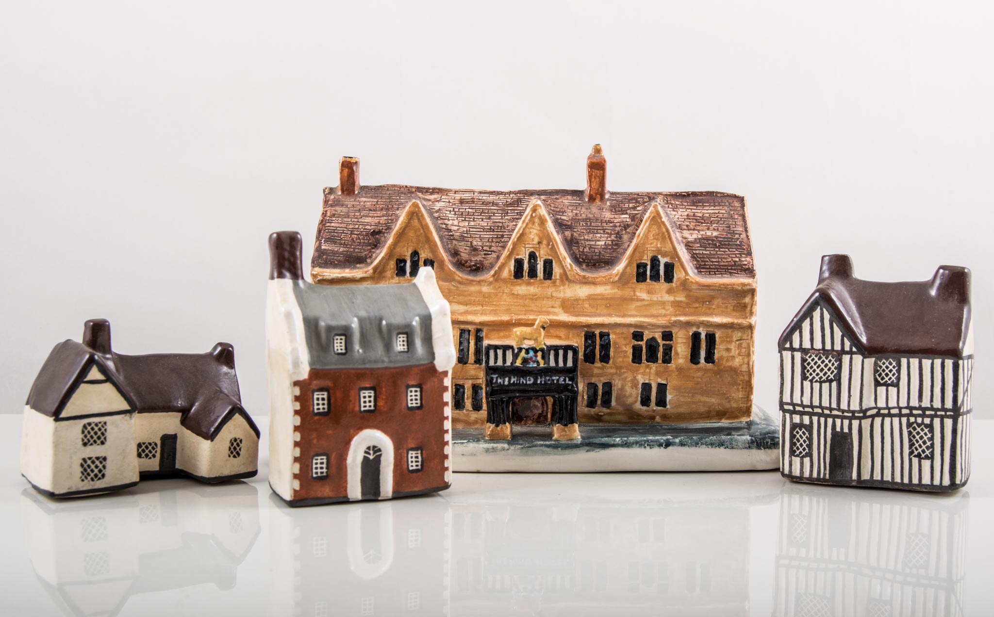 Collection of pottery cottage models, including "The Hind Hotel, Wellingborough", 18cms.