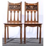 A pair of English Arts & Crafts oak and copper hall chairs,