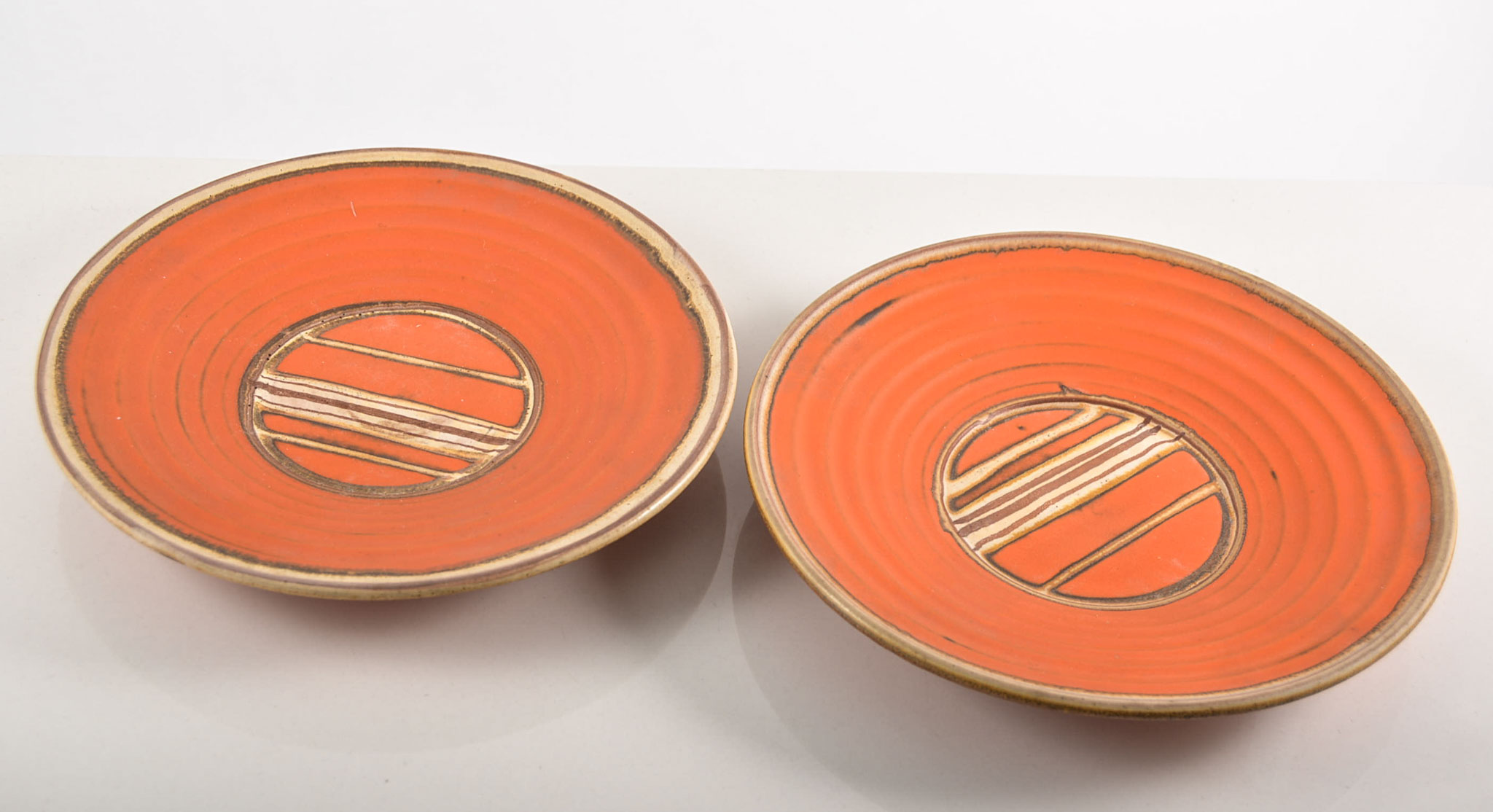 Studio fruit set, circular form with concentric moulded bands, orange glazed, comprising charger,