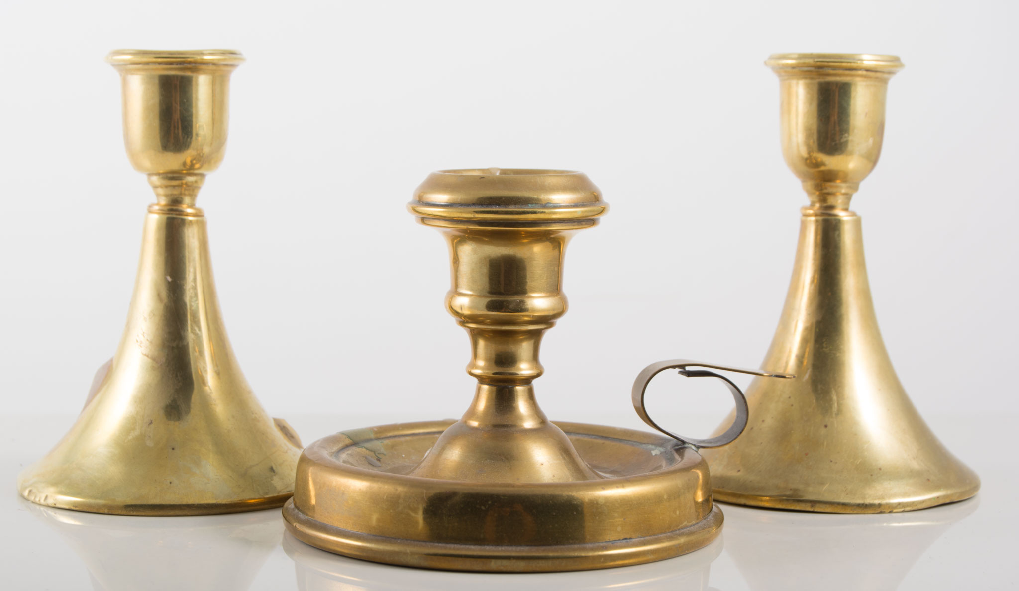 Pair of brass candlesticks and a chamberstick, (3).