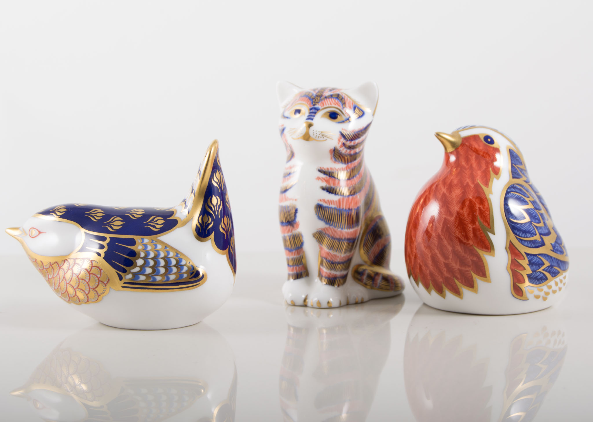 Three Royal Crown Derby paperweights, including a Robin and Wren and Kitten.