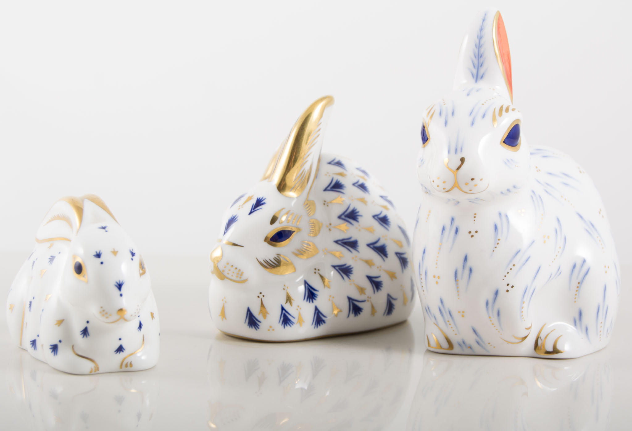 Three Royal Crown Derby Rabbit paperweights, varying sizes.