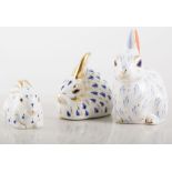 Three Royal Crown Derby Rabbit paperweights, varying sizes.