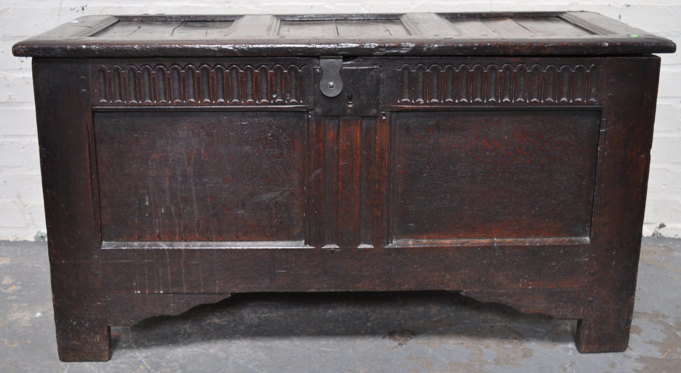 A joined oak coffer, hinged top, knulled frieze, two panel front, 18th Century and later.