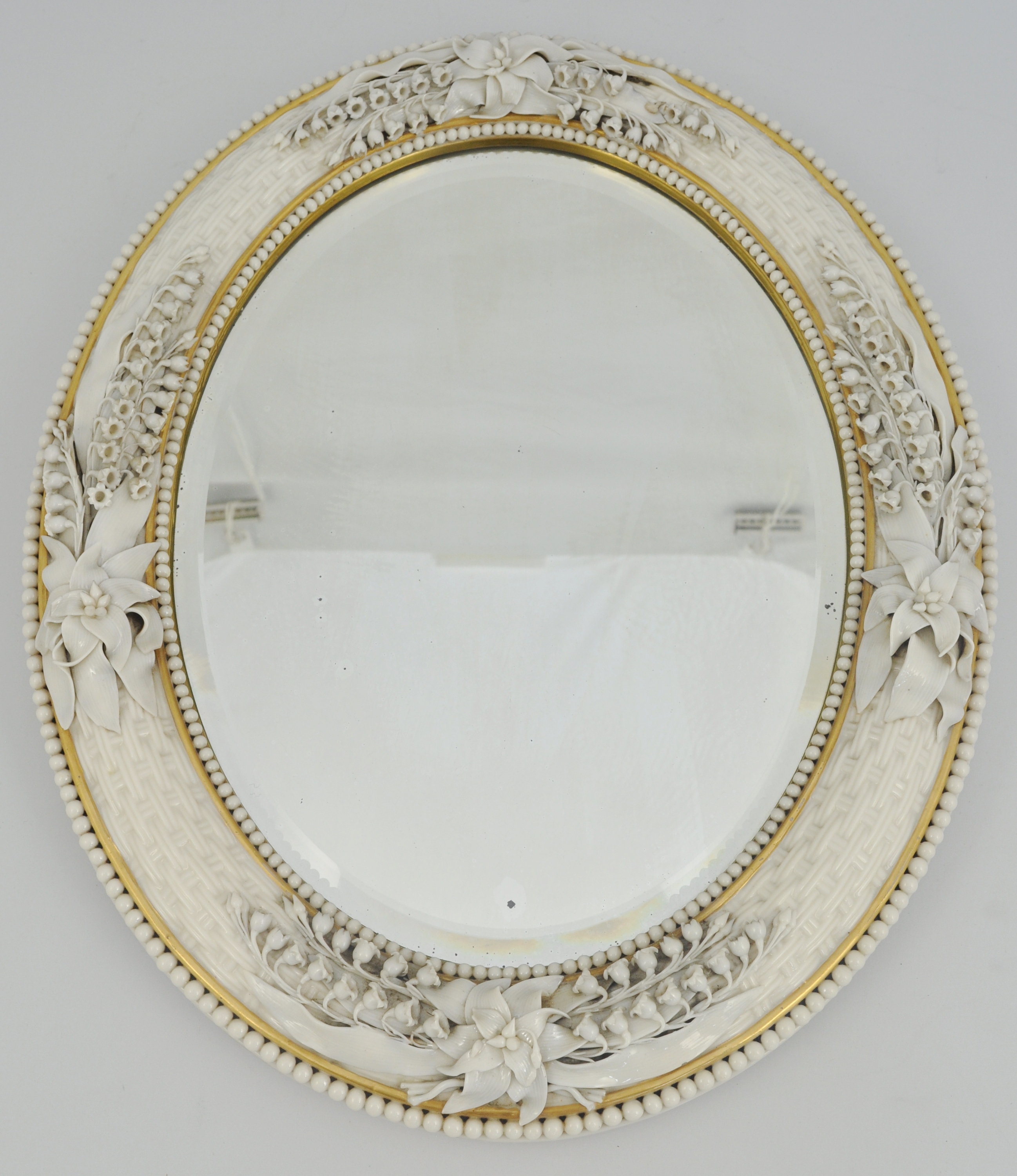 Porcelain mounted oval mirror, probably Belleek, basket weave moulded,