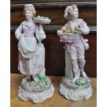 Pair of Continental porcelain figures, in the Meissen style, lady with a basket of flowers,