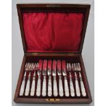 A set of six silver and mother of pearl dessert knives and forks, walnut case.