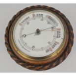 A circular aneroid barometer in an oak rope twist case, diameter 21cms.