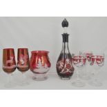 Ruby slice cut decanter, four similar pedestal wines, water jug and three glasses,