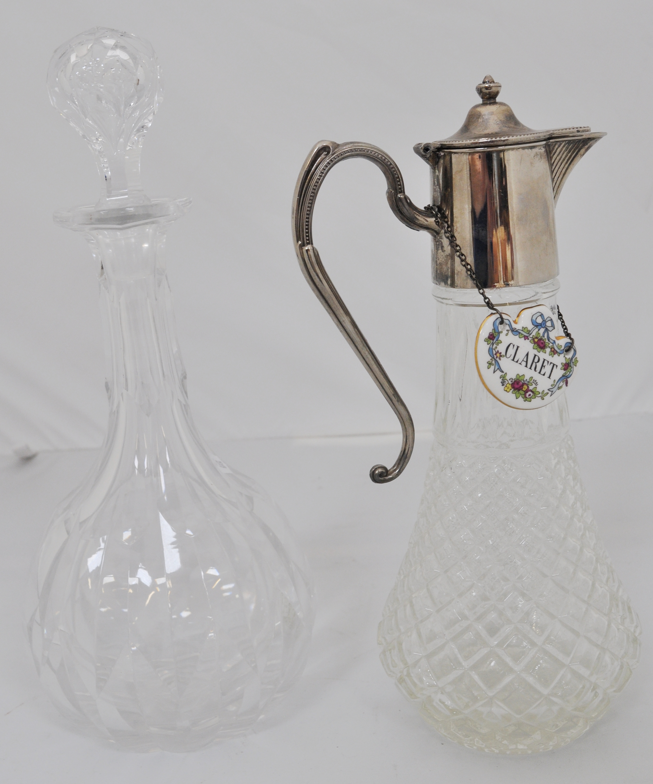 A cut glass cocktail shaker 26cm, jug, two decanters and a plated claret jug, (5).