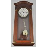 A modern wall clock, mahogany effect case, with pendulum, 63cm.
