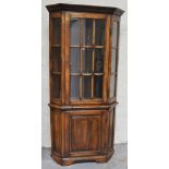 An oak and glazed standing corner cupboard in the Titchmarsh & Goodwin style, height 201cm.