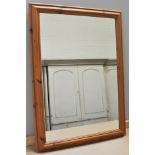 A large wall mirror in a pine frame, 103x73cm, and a pine wine cupboard, (2).